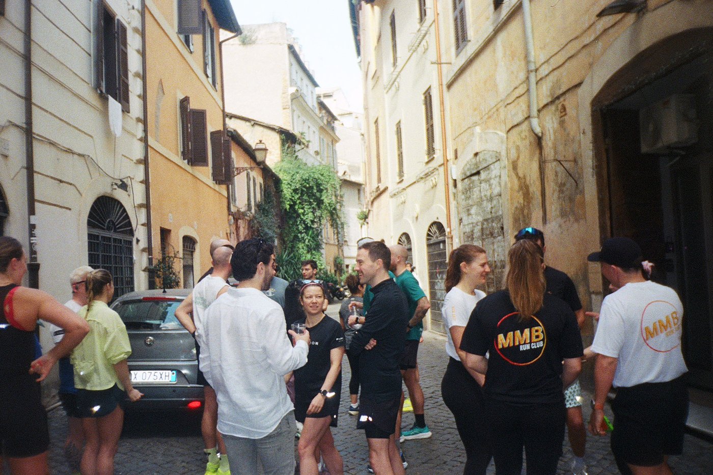 A group of runners talking together in a cobblestone street